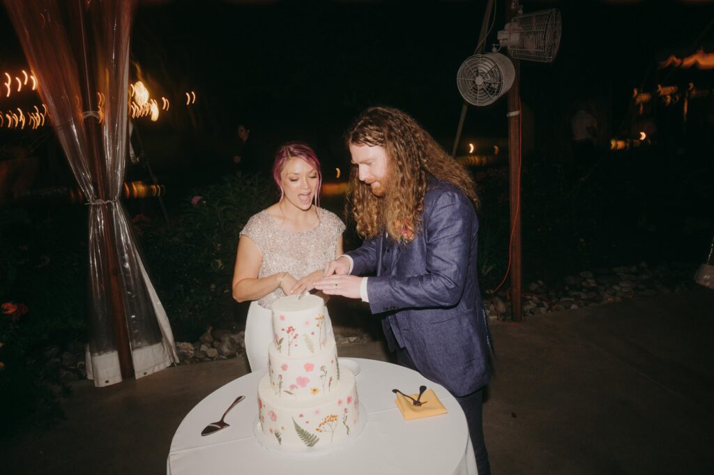 Newlyweds cutting cake together.