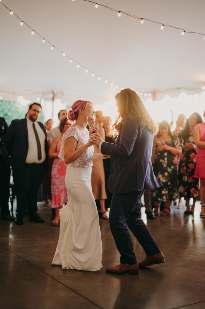 Newlyweds on the dance floor surrounded by guests.