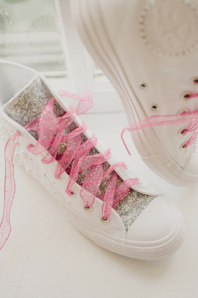 Bride's custom converse, with glitter and pink glitter ribbon shoe laces.