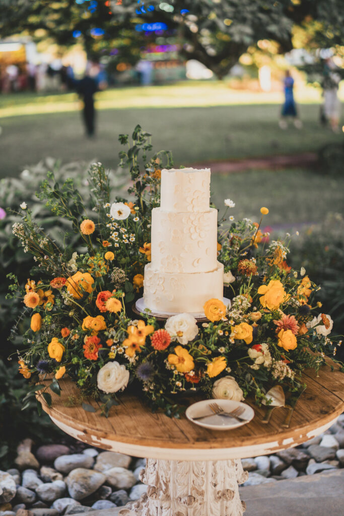Wedding cake surrounded by lush fall floral.