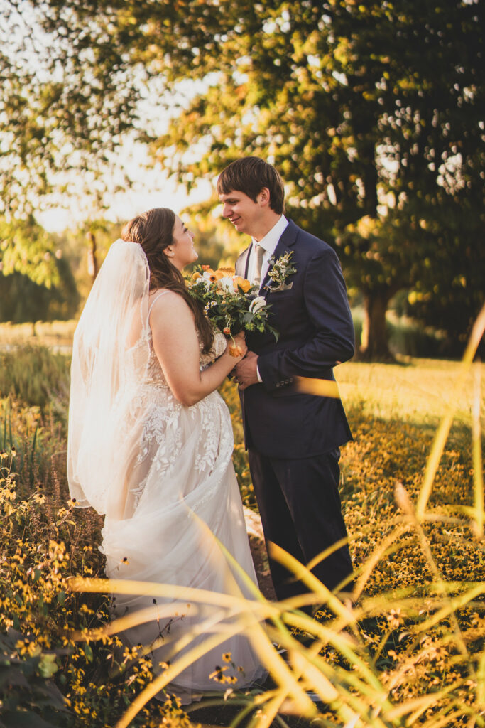 Newlyweds embrace in a golden garden.