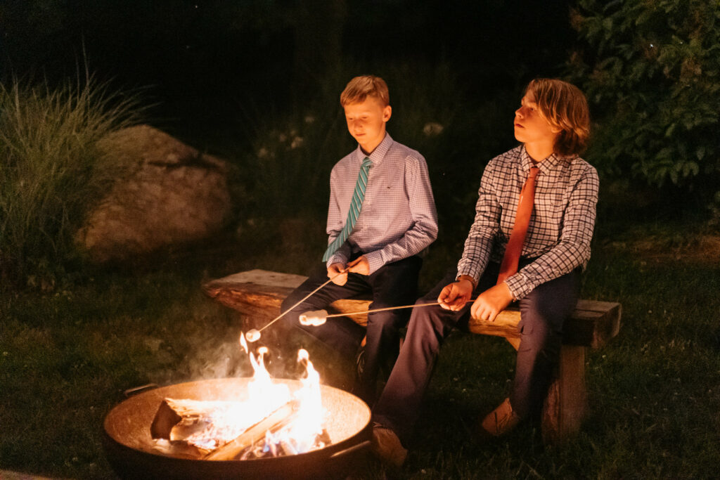 Guests roasting marshmallows at bonfire.
