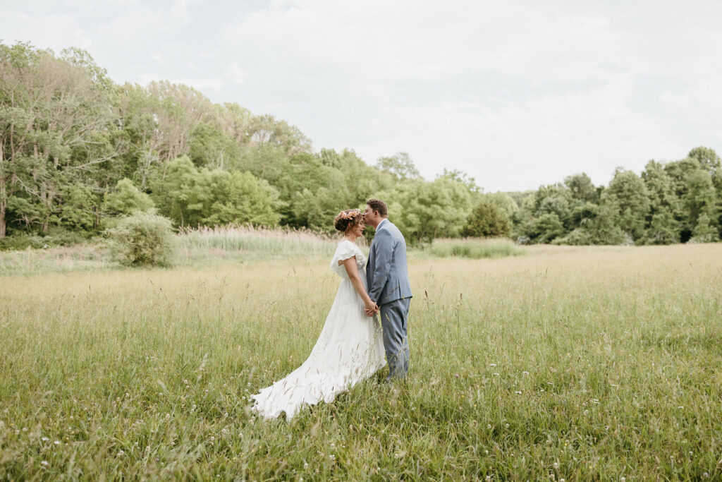 Newlyweds in the grassy field.