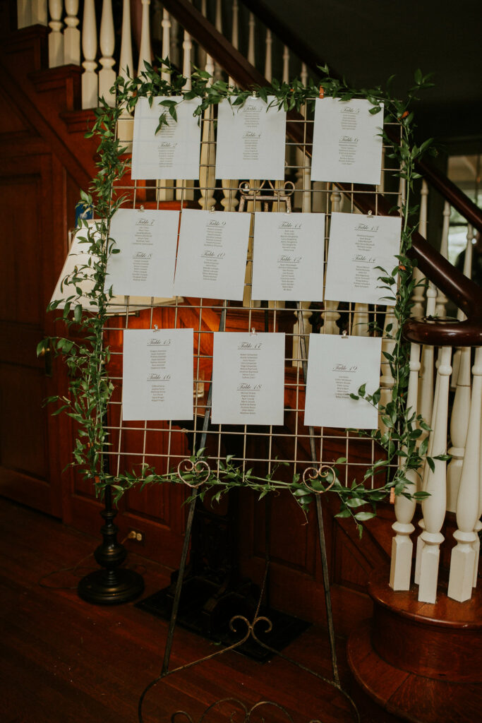 Cards with place settings on a wire grid with ivy going up.