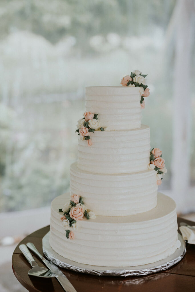 Wedding cakes with four tiers and edible flowers on each layer.