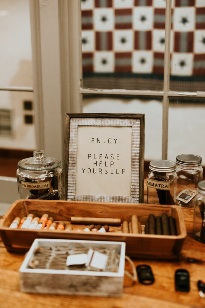 Cigar basket and matches with a sign that says please enjoy yourself.