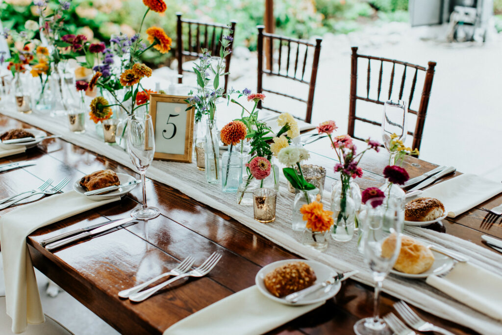 Dinner table with floral decor on top of runner.