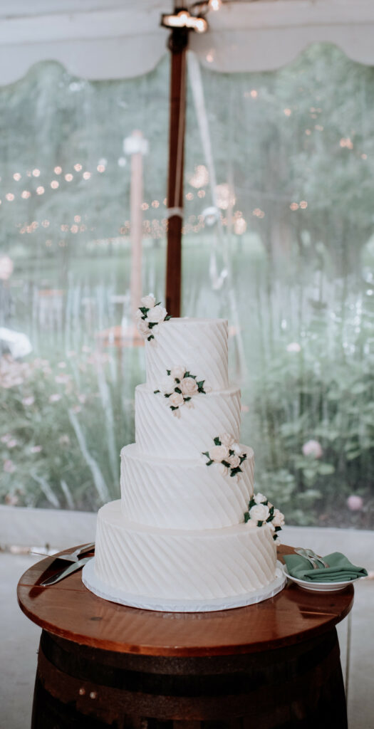 Tiered wedding cake with flowers spiraling up.