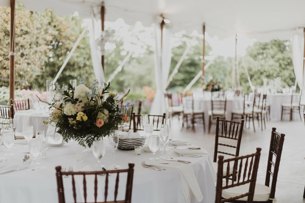 Table with floral centerpieces in the reception tent.