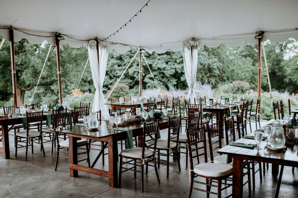 Long wooden tables set up in the open main tent at Springton manor Farm