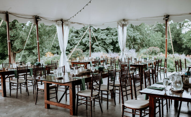 Long wooden tables set up in the open main tent at Springton manor Farm