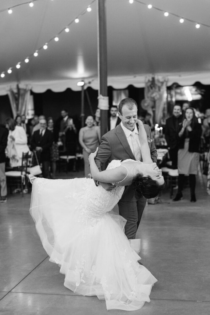 Groom dips bride on the dance floor.