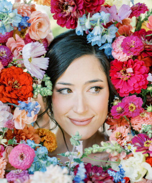 Brides face surrounded by bouquets.
