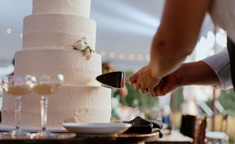 close up of wedding couple cutting a four tier cake