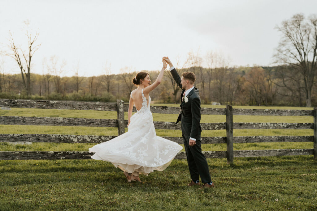 Newlyweds dancing in the pasture.