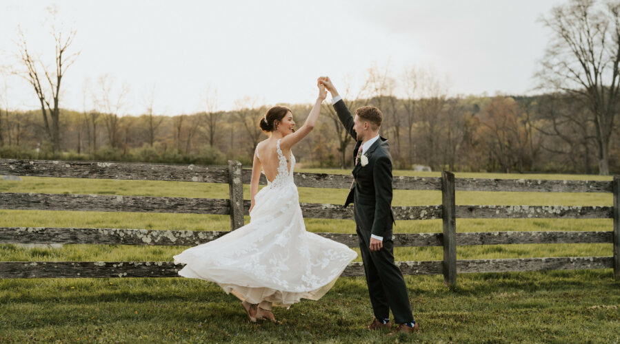 Newlyweds dancing in the pasture.