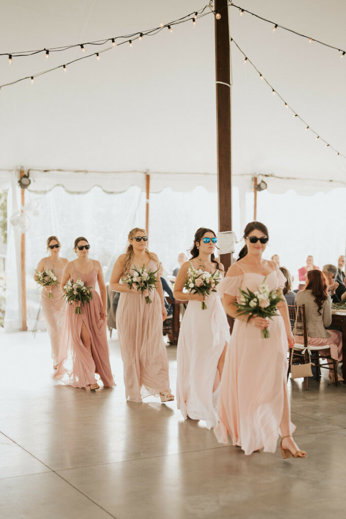 Bridemaids wearing sunglasses walking into the reception.