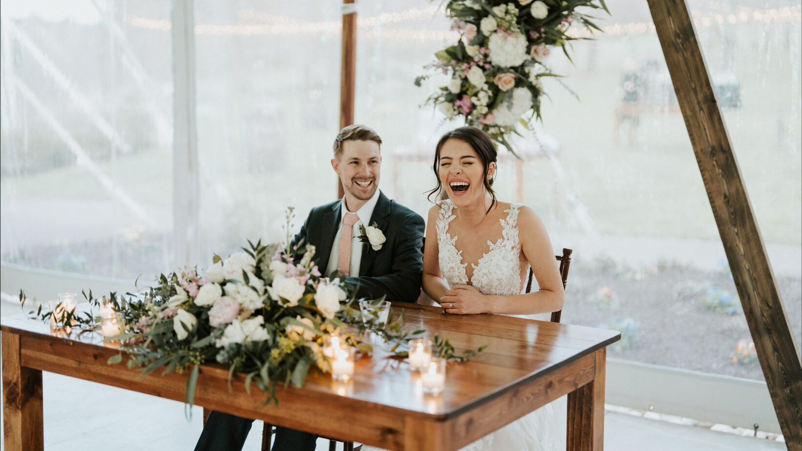 Wedding couple laughing at head table