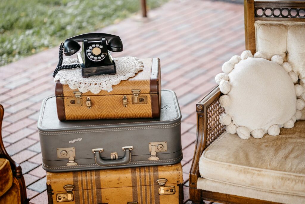 Stacked vintage suitcases and a rotary phone.