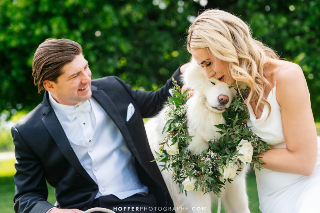 Newlyweds hugging their dog.