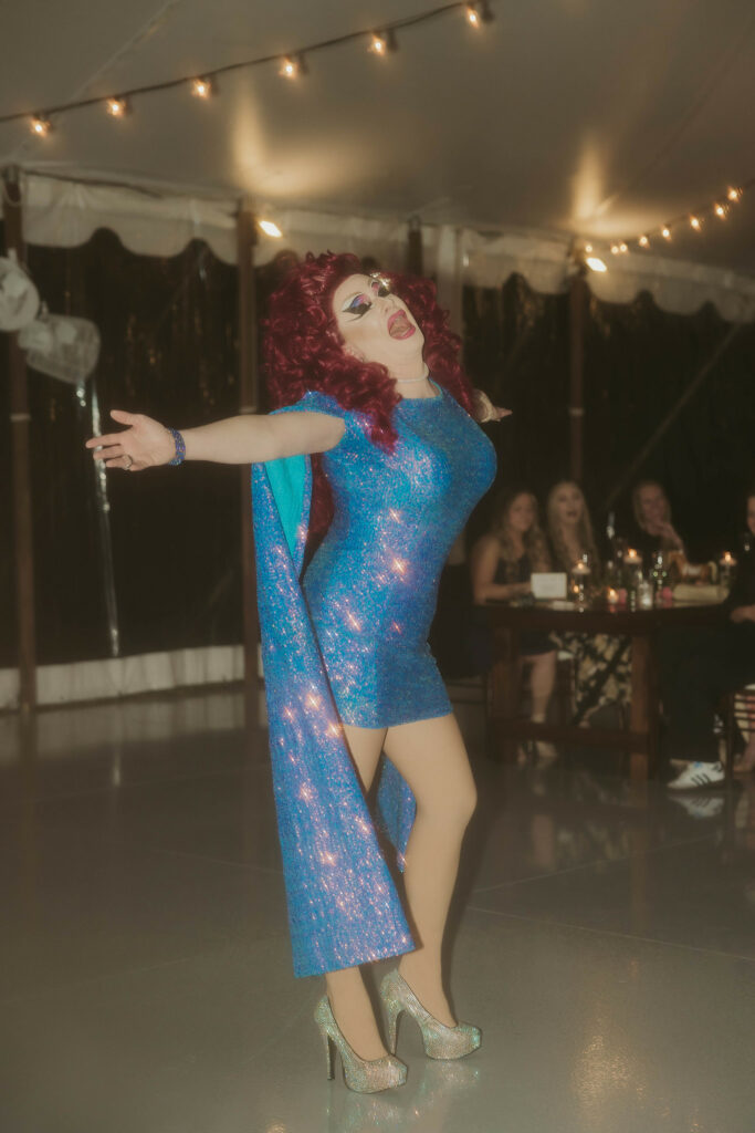 Drag queen singing on the dance floor.