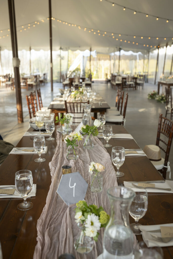 Reception table close up of floral decor under tent.